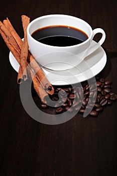 Coffee cup, coffee beans and cinnamon.