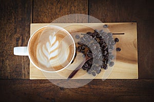 Coffee cup and coffee beans on old wooden background, Top view