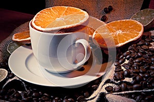 Coffee cup with coffee beans, orange and lemon