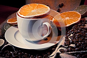 Coffee cup with coffee beans, orange and lemon photo