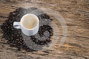 Coffee cup and coffee beans roasted in sack on a wooden floor