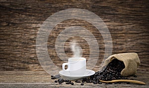 Coffee cup and coffee beans roasted in sack on a wooden floor