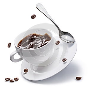 Coffee cup, coffee beans and spoon flying over a white plate isolated on white background