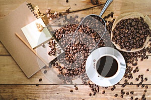 Coffee cup and Coffee beans spread on the table wooden old with copys for your text