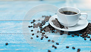 Coffee cup with coffee beans on vintage wooden table.