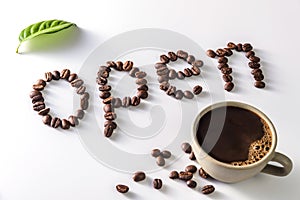 Coffee cup and coffee beans on white background with open Text made of coffee beans