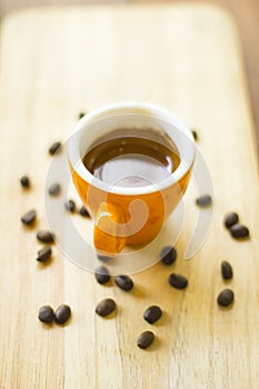 Coffee cup and coffee beans on wood