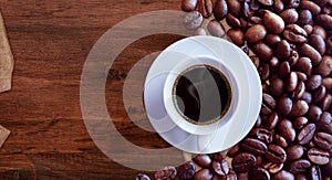 Coffee cup and coffee beans on wood table background vintage style for graphic design