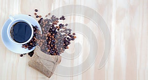 Coffee cup and coffee beans on wood texture background. View from top and free space for text