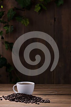 Coffee cup and coffee beans on wooden