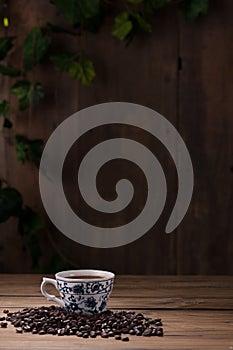 Coffee cup and coffee beans on wooden