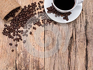 Coffee cup and coffee beans on wooden background with copy space