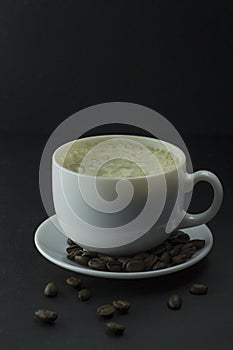 Coffee cup and coffee beans on wooden table