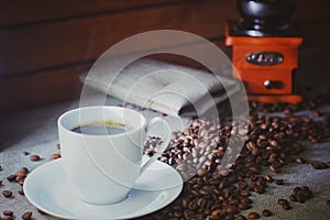 Coffee cup with coffee beans on a wooden table