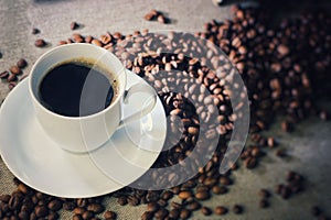 Coffee cup with coffee beans on a wooden table