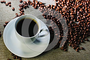 Coffee cup with coffee beans on a wooden table