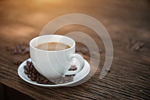 Coffee cup and coffee beans on wooden table.