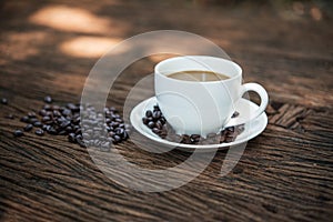 Coffee cup and coffee beans on wooden table.