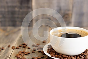 Coffee cup and coffee beans on wooden table.