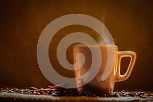 Coffee cup and coffee beans on a wooden table and sack background, Vintage color tone