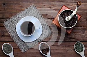 Coffee cup, coffee grinder and spices on a wooden table, top vie
