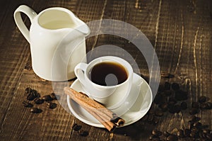 Coffee cup, creamer with cinnamon the scattered coffee beans/coffee cup, creamer with cinnamon the scattered coffee beans on a