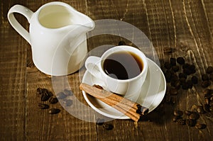 coffee cup, creamer with cinnamon the scattered coffee beans/coffee cup, creamer with cinnamon the scattered coffee beans on a