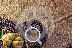 Coffee cup and Croissant on beans and sack