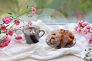 Coffee cup and dessert with pink roses on the window sill , romantic morning photo