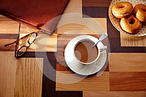 Coffee cup and dona with glasses on table retro photo