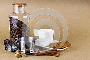 Coffee cup, dripper, cookies, and a glass jar of coffee beans.