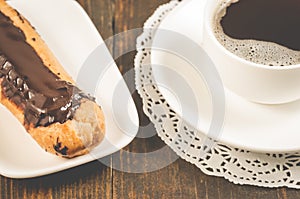 coffee cup and eclair/coffee cup and eclairs on a wooden background. Selective focus