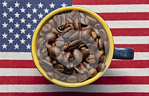 A coffee cup filled to the brim with roasted coffee beans stands on the American flag. Concept: American coffee, rich taste, expor
