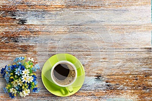 Coffee cup and flower on old wooden table background