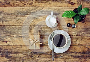 Coffee cup, flower pot, milk jug, gift box on wooden table