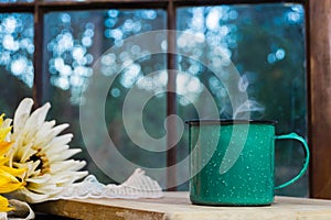 Coffee cup in front of paned window