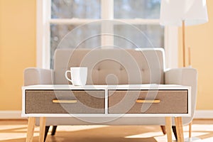 Coffee cup and gray midcentury loveseat