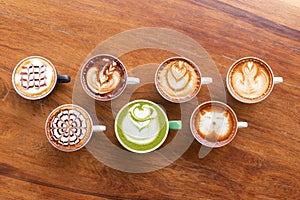 Coffee cup with Green Matcha latte art foam on wood table in coffee shop with copy space.Coffee is one of the most popular