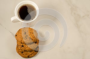 Coffee cup and homemade cookies with chocolate/coffee cup and homemade cookies with chocolate on a marble background, top view and