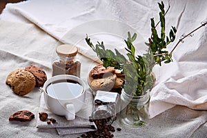 Coffee cup, jar with coffee beans, cookies on white table selective focus, close-up, top view