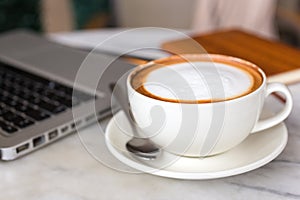 Coffee cup and laptop for business on table, close up macro