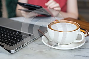 Coffee cup and laptop for business on table, close up macro