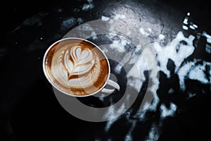 Coffee cup with latte art on the floor