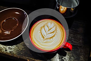 Coffee cup with latte art on the wood table