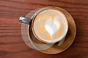 Coffee cup latte art on wooden table background.frothy milk texture on arabica coffee for coffee break time