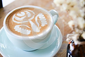 Coffee cup with Latte art on wooden table menu in coffee break time.Latte art froth design pattern is a method of preparing coffee