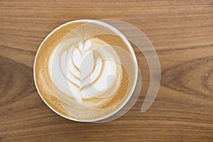 Coffee cup with Latte art on wooden table menu in coffee break time.Latte art froth design pattern is a method of preparing coffee