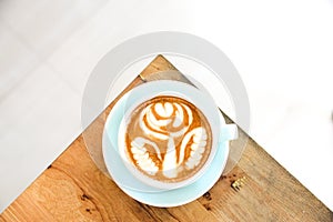 Coffee cup with Latte art on wooden table menu in coffee break time.Latte art froth design pattern is a method of preparing coffee