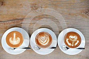 Coffee cup with Latte art on wooden table menu in coffee break time.Latte art froth design pattern is a method of preparing coffee