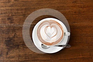 Coffee cup with Latte art on wooden table menu in coffee break time.Latte art froth design pattern is a method of preparing coffee